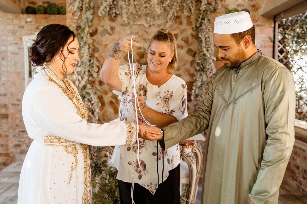 Tracey tying a handfasting cord for a couple during a wedding ceremony